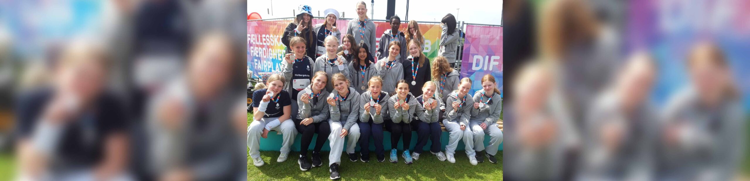 Hele syvende aargang fra Holbergskolen i Dianalund sidder og står bag ved hinanden i tre rækker og viser glade go stolte deres OL sølvmedaljer frem